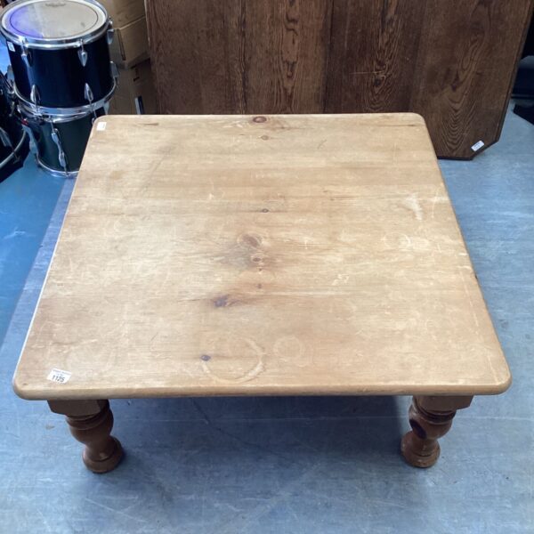 Rustic pine coffee table with turned legs, farmhouse style.