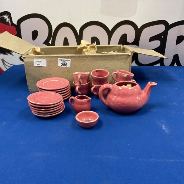 Vintage pink porcelain children’s tea set with teapot and cups.