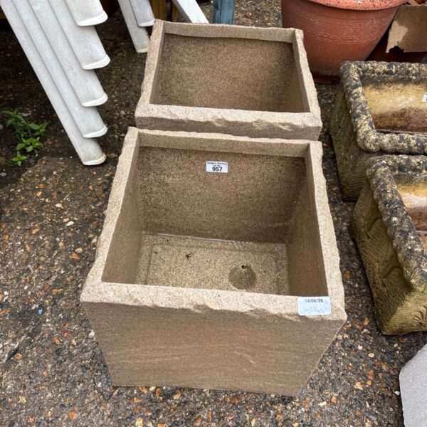 Pair of square plastic garden planters for outdoor use.