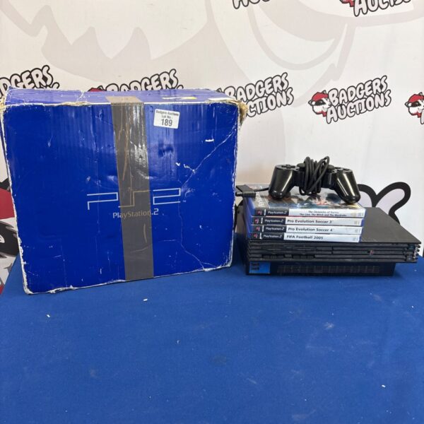 Boxed Sony PlayStation 2 console with games and controller.