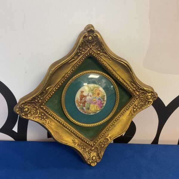 Antique porcelain plaque with romantic scene in gilt frame.