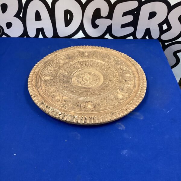 Vintage pottery charger plate with detailed embossed floral design.