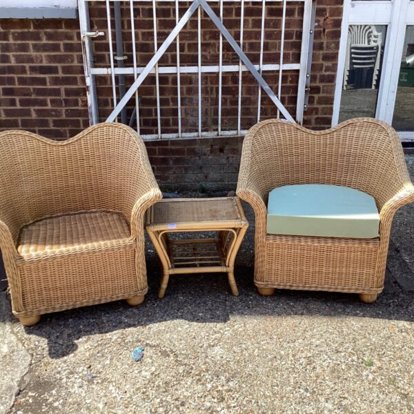 Vintage rattan conservatory furniture set with two chairs and a table.