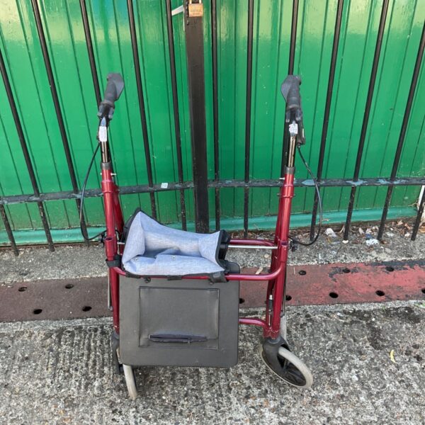 Red mobility rollator with a padded seat and storage bag.