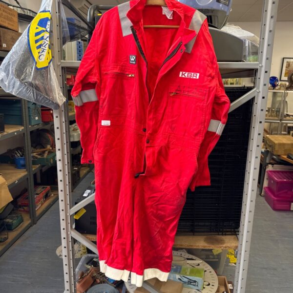 Red KBR oil rig overalls hanging on a rack.