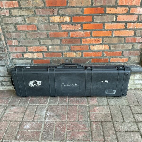 Large hard plastic rifle transit case showing exterior wear.