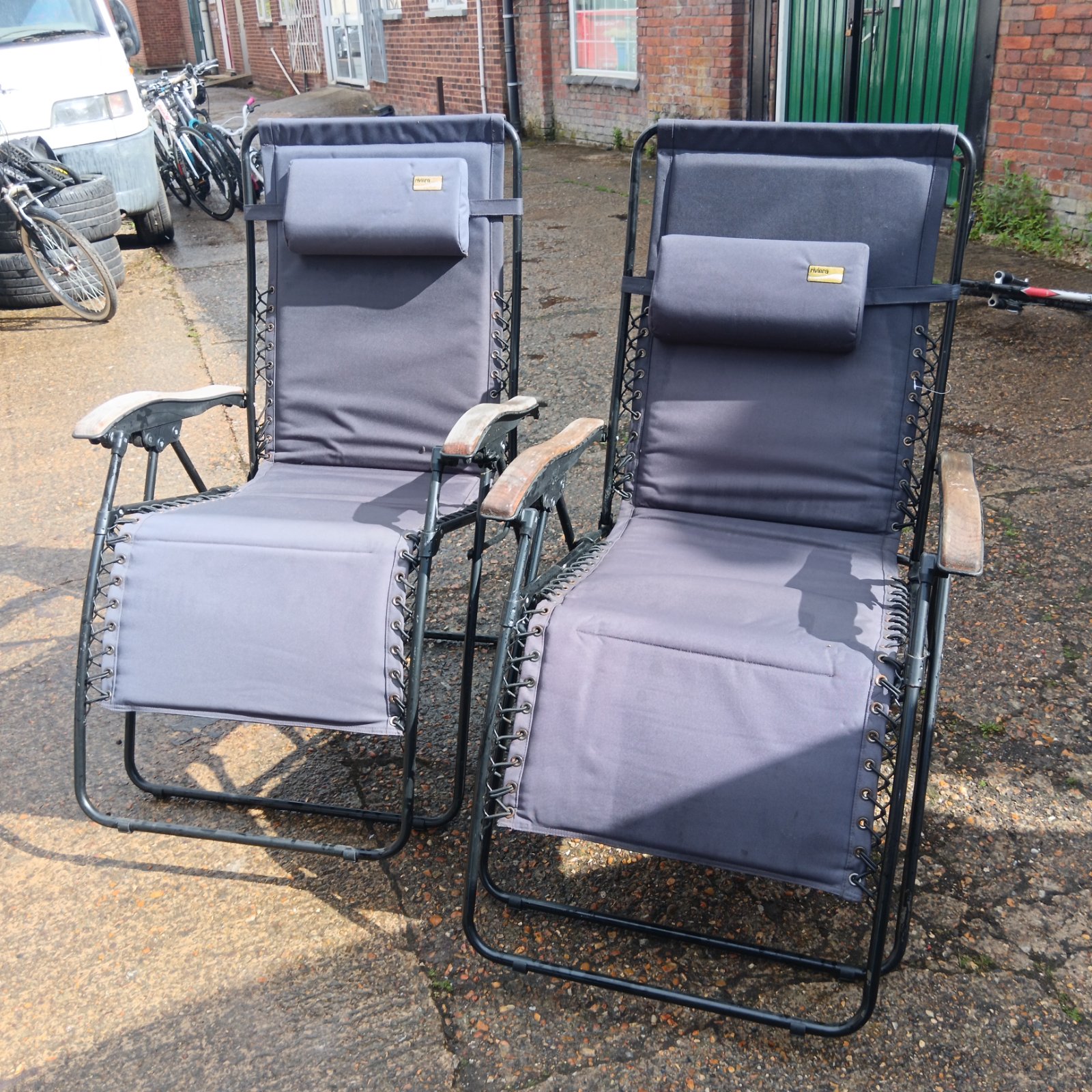 Two grey Riviera Garden recliner chairs in a garden setting.