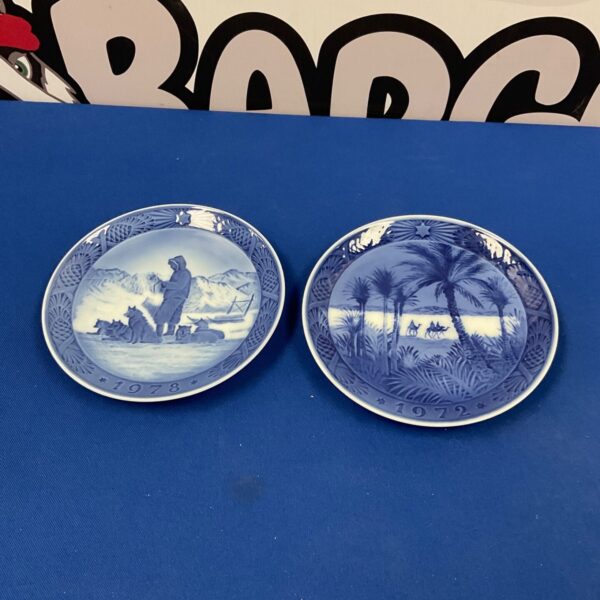 Pair of Royal Copenhagen porcelain wall plates with blue and white scenes.