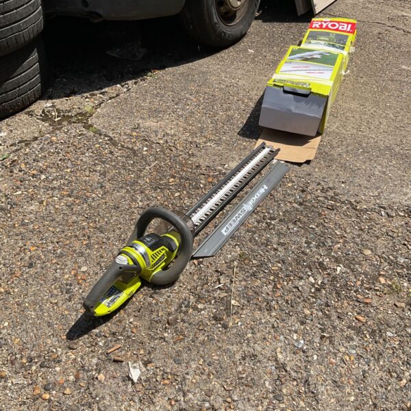 Used Ryobi hedge trimmer for garden landscaping.
