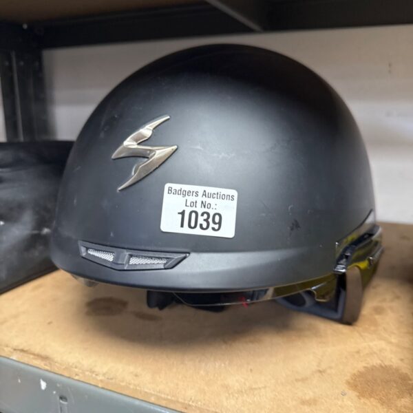Black Scorpion motorcycle helmet with auction sticker.
