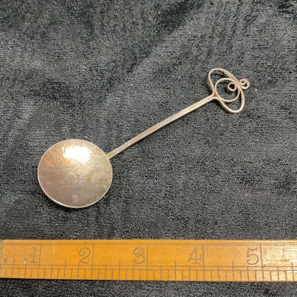Antique Scottish silver jam spoon with decorative handle.