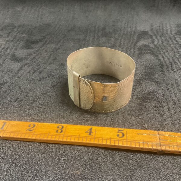 Vintage silver cuff bracelet with textured design.