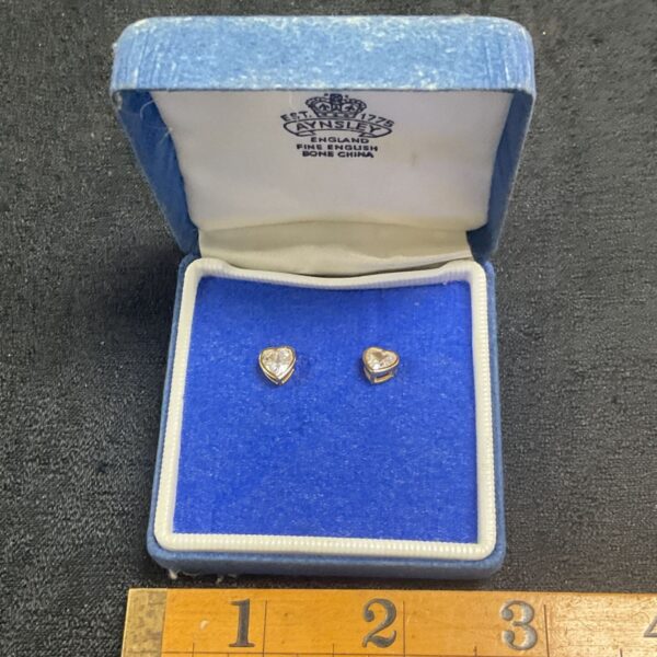 Silver gilt heart stud earrings with white stone detail.