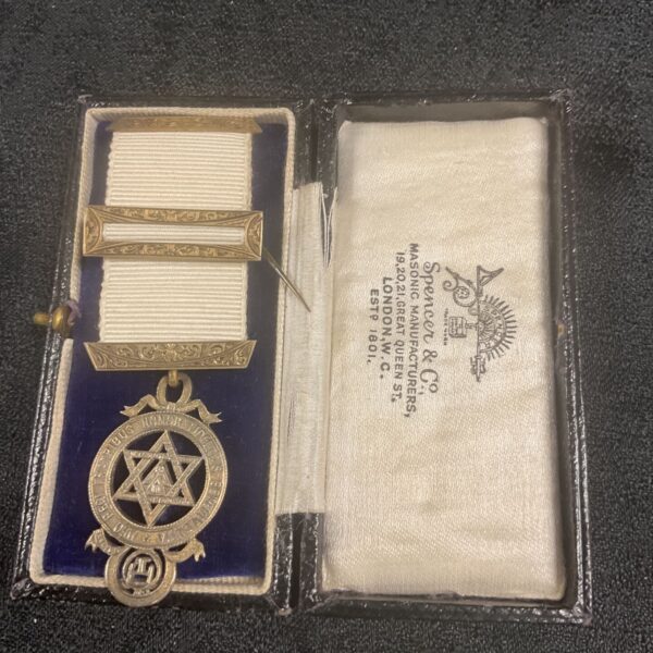 Antique silver masonic jewel with ribbon suspension and detailed engraving.