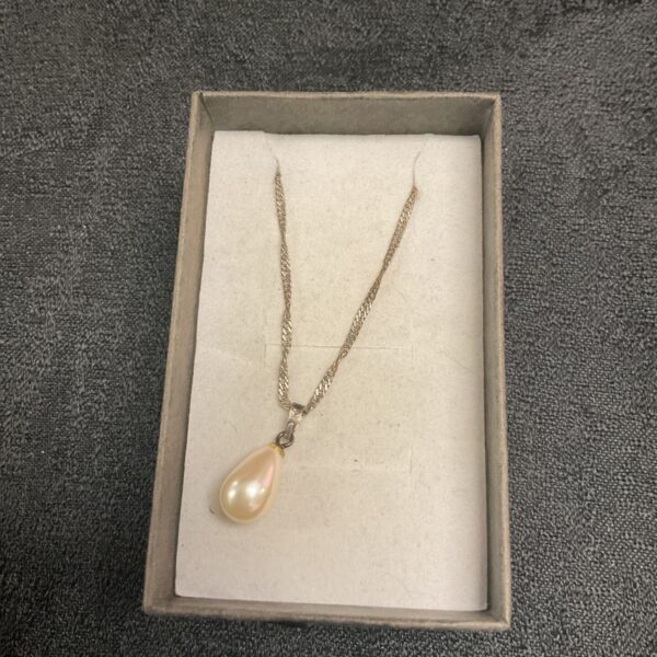 Delicate silver necklace with a pearl pendant.