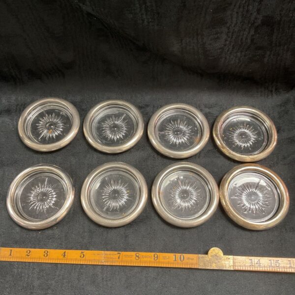 Set of eight silver plated glass coasters for barware.