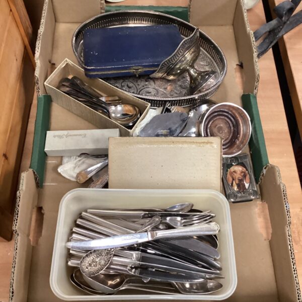 Assorted vintage silverware and tableware in a cardboard box.