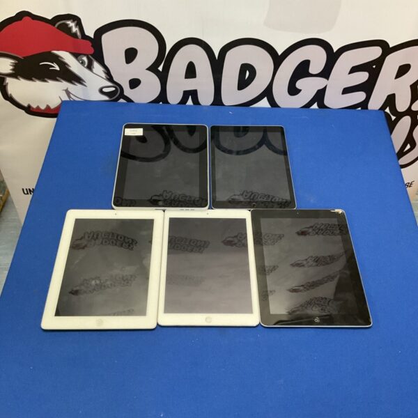 Stack of four used Apple iPads for parts or repair.