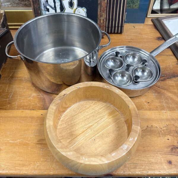 Stainless steel cooking pot with egg poacher and wooden fruit bowl.