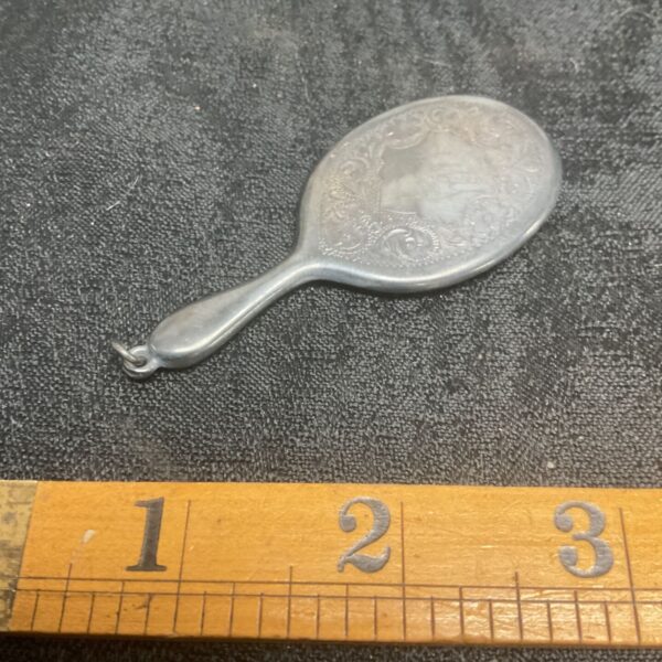 Antique sterling silver chatelaine mirror with embossed floral design.
