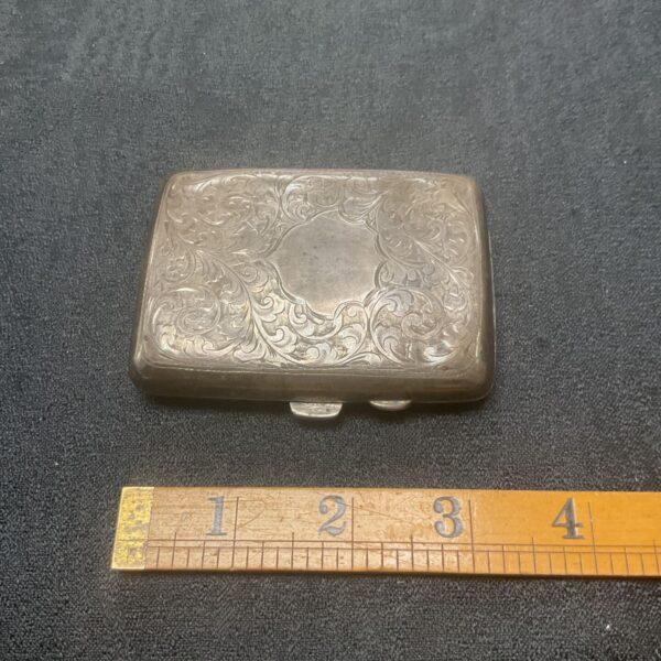 Ornate sterling silver cigarette case with engraved details.