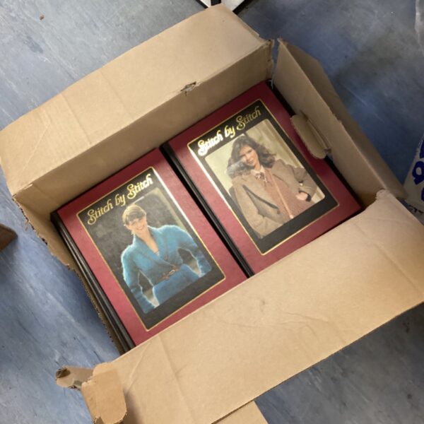 Vintage stitch by stitch books inside a cardboard box.