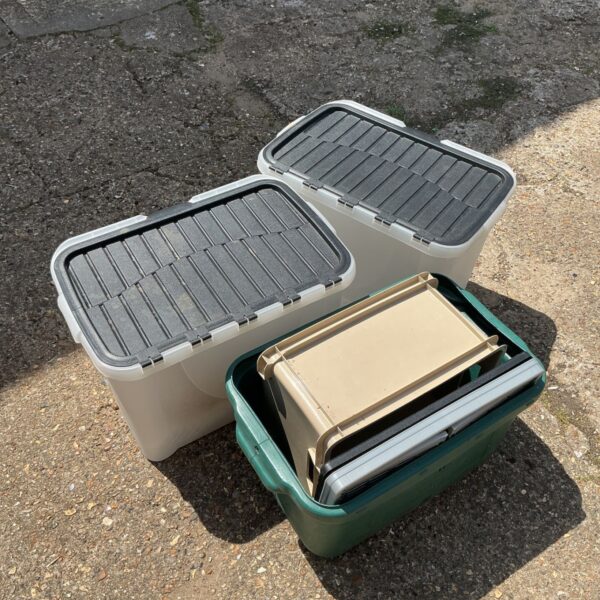Selection of three plastic storage boxes with lids for household storage.