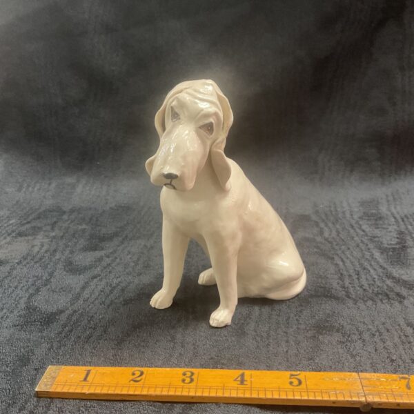 Vintage studio pottery bloodhound figurine with ruler for scale.