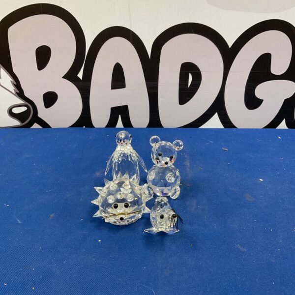 Swarovski crystal animal set featuring a bear, hedgehog, penguin, and otter.