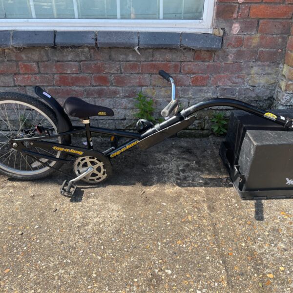 Black Tag-a-long trailer bike with tow bar and 20 inch wheel.