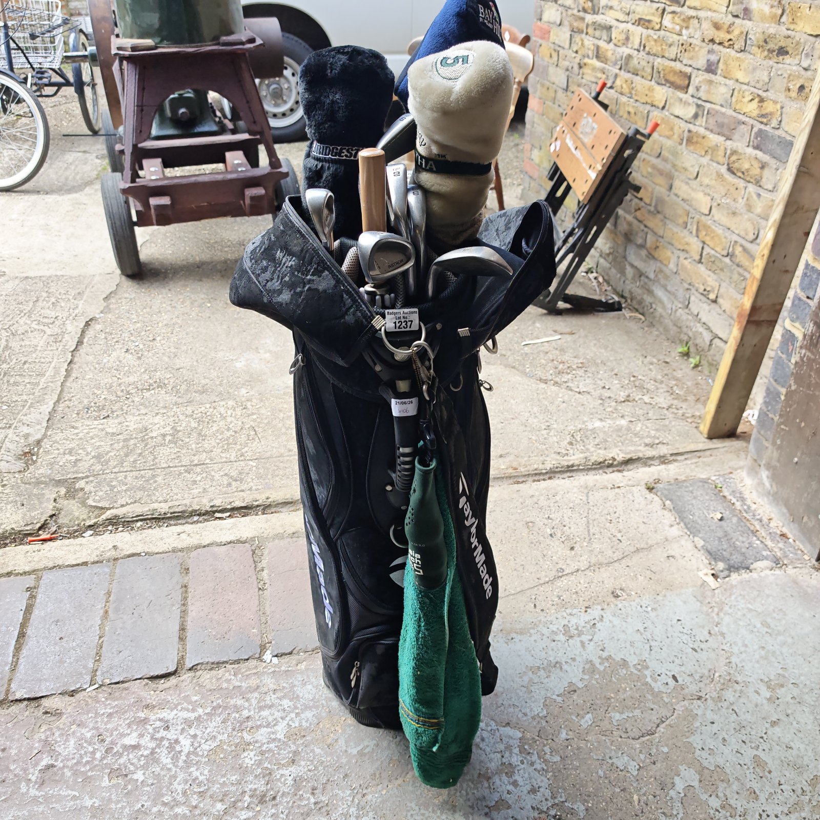 TaylorMade golf bag with MTS clubs in a garden setting.