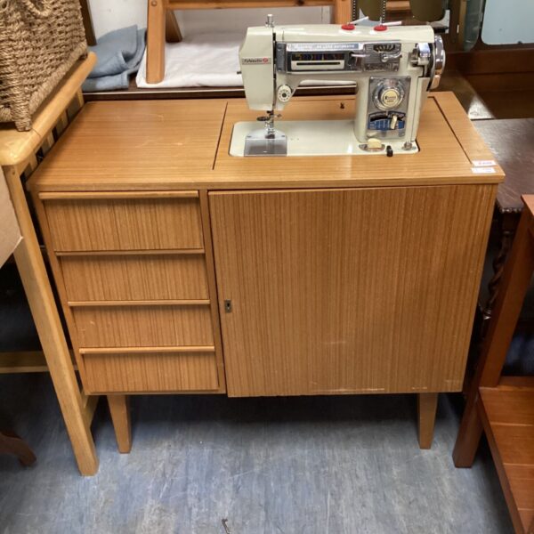 Vintage teak sewing machine cabinet with drawers, mid-century style.