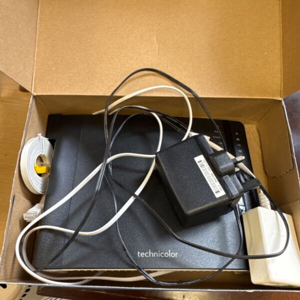 Technicolor broadband router with cables attached, side view.