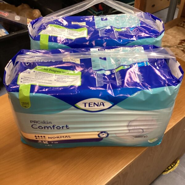 Two unopened packs of Tena Comfort Pads Normal for incontinence.
