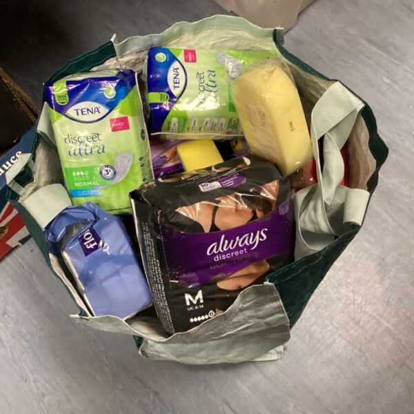 Lot of Tena Discreet pads, first aid kit, and tissues for personal care.