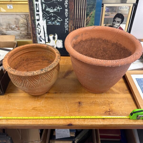 Pair of vintage terracotta garden pots, one with cracks.