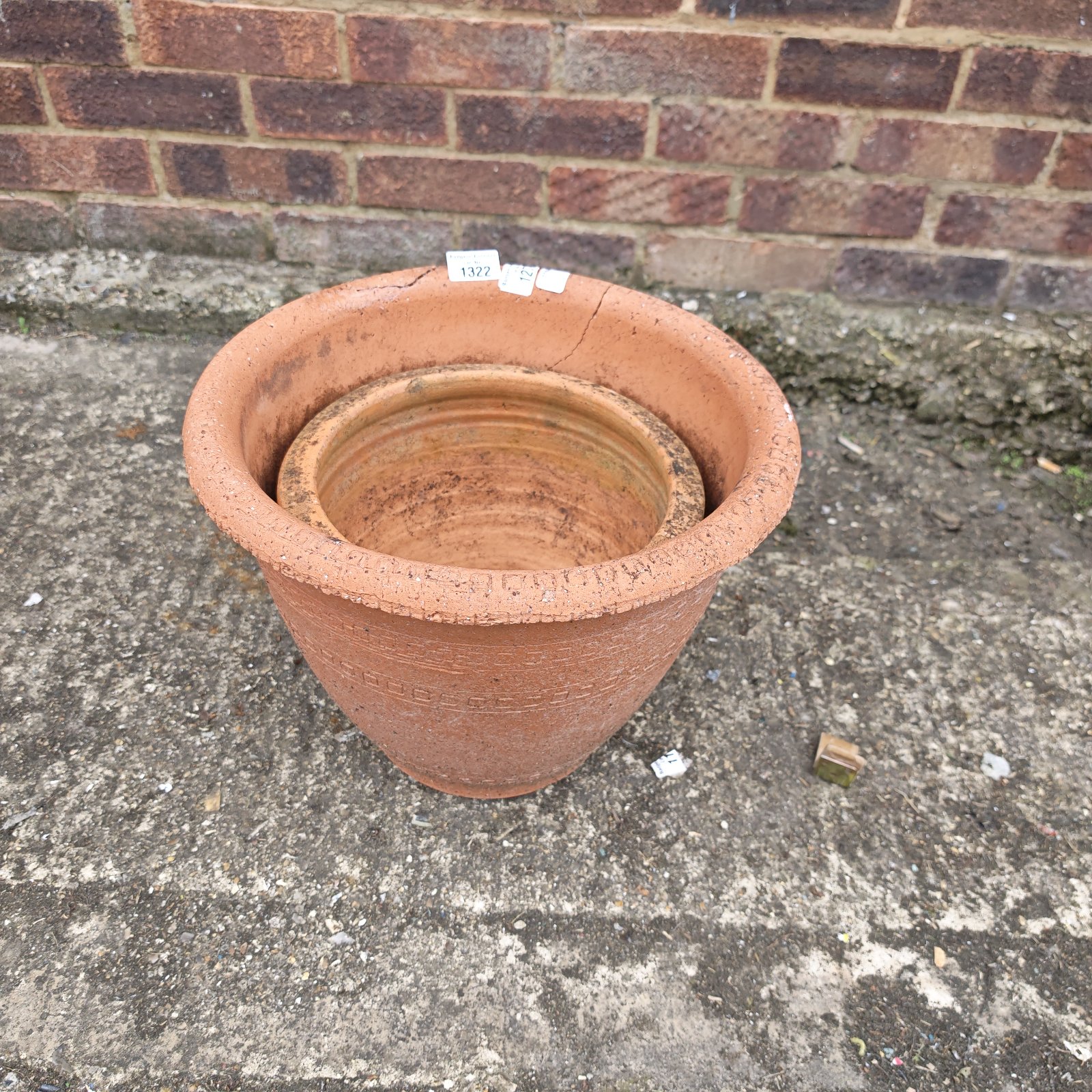 Two weathered terracotta ceramic plant pots for garden use.