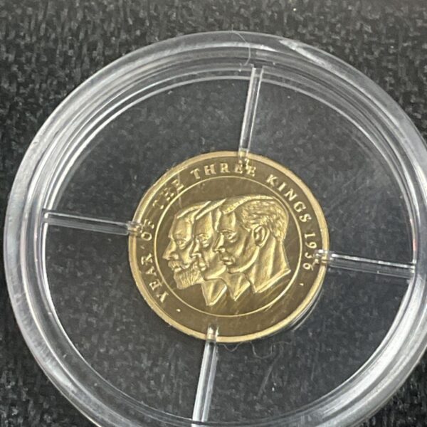 Gold coin featuring the three kings: George V, Edward VIII, and George VI.