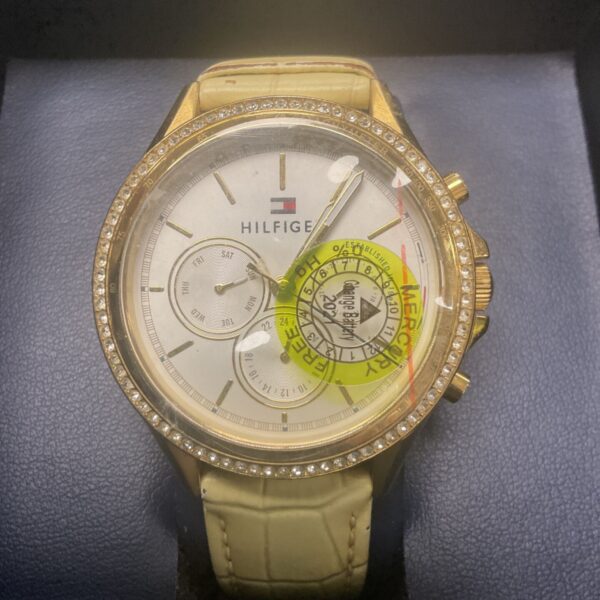 Gold tone Tommy Hilfiger wristwatch with crystal bezel.