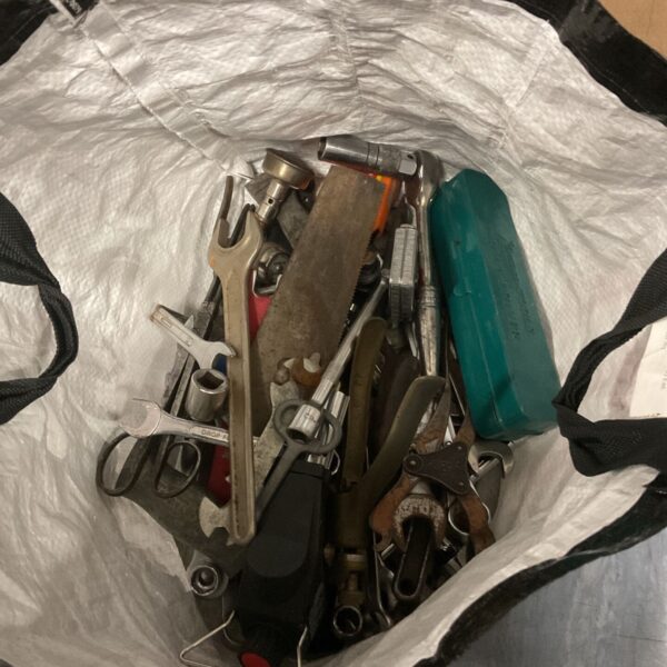 Assorted hand tools in a tool lot, including wrenches and pliers.