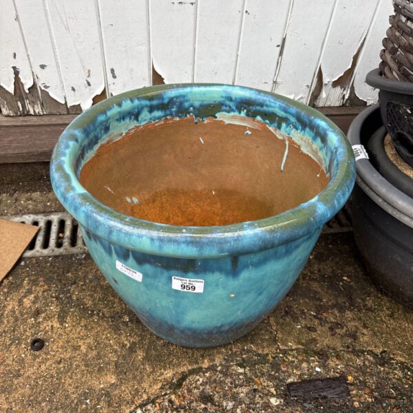 Vibrant turquoise glazed terracotta planter for garden display.