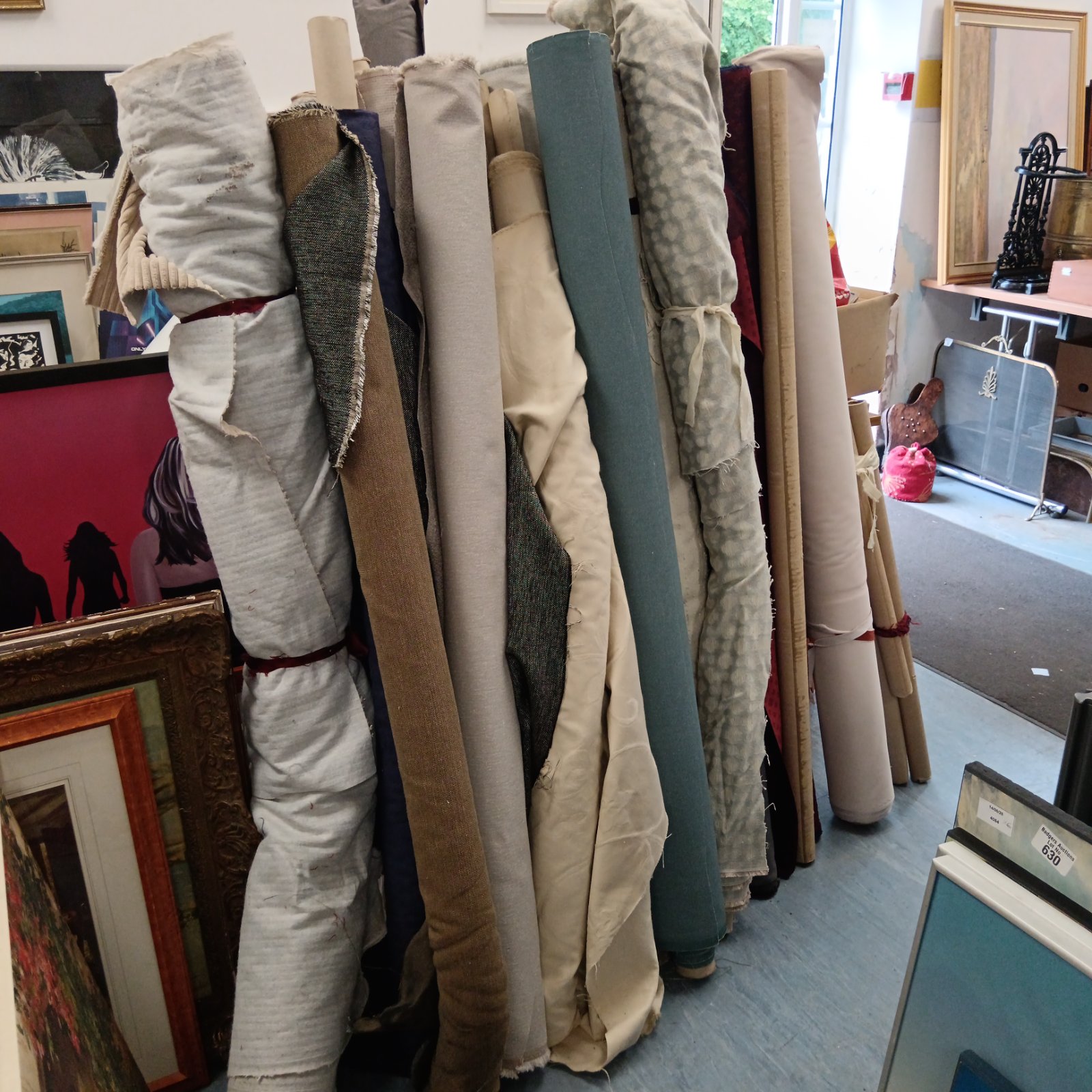 Assorted rolls of upholstery fabric in a large lot.
