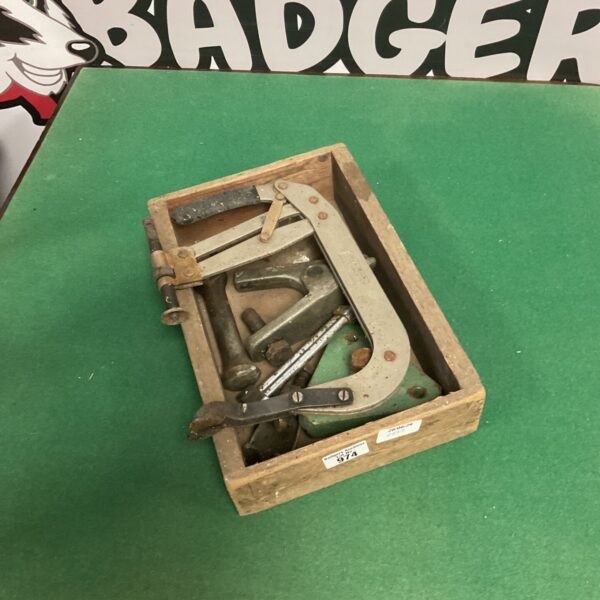 A box containing a collection of metal vices for workshop use.
