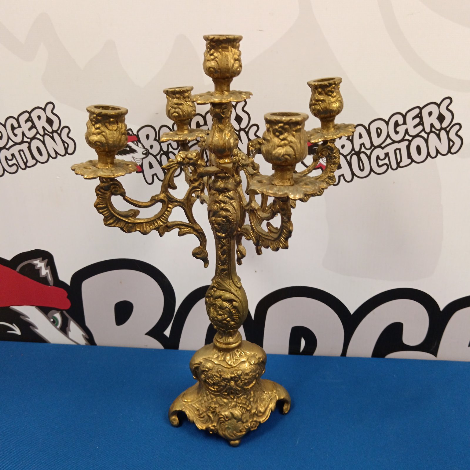 Ornate Victorian brass candelabra with five arms and detailed scrollwork.