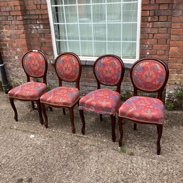 Set of four Victorian dining chairs with red patterned upholstery.