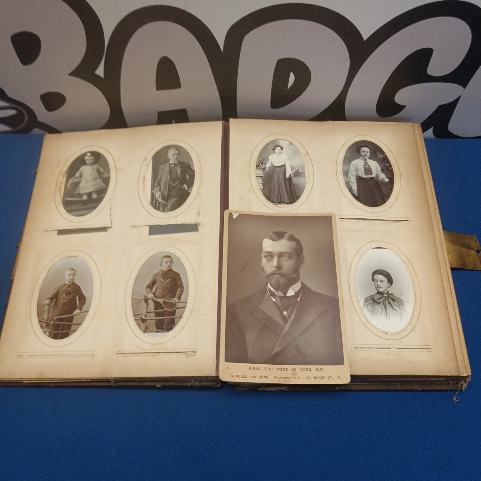 Victorian photo album with eight antique photographs displayed inside.
