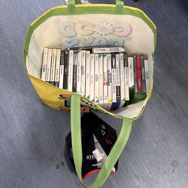 Mixed lot of video games in a green tote bag.