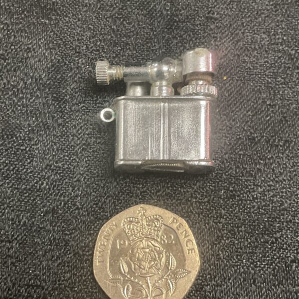 Vintage Aladin USA petrol lighter next to a 20 pence coin.