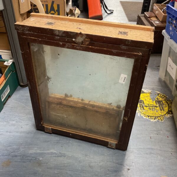 Vintage bee observation window with wooden frame and glass pane.