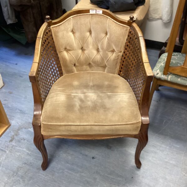 Vintage beige velvet accent chair with carved wood details.